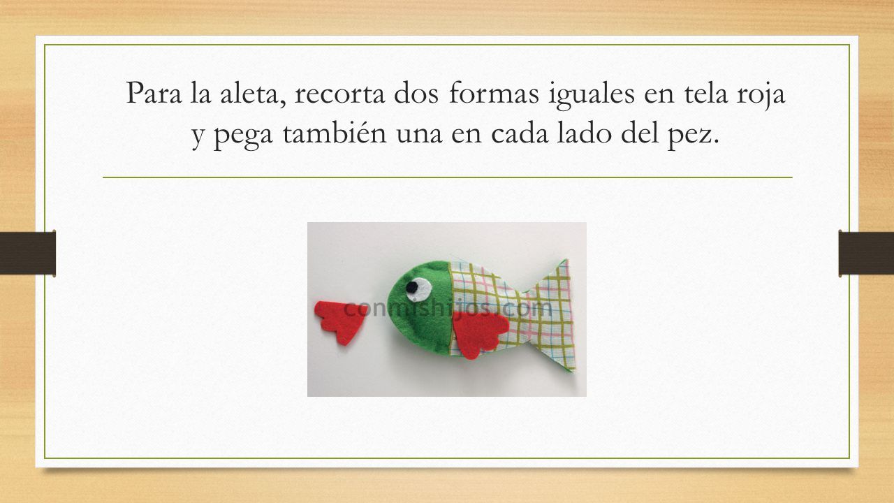 Para la aleta, recorta dos formas iguales en tela roja y pega también una en cada lado del pez.