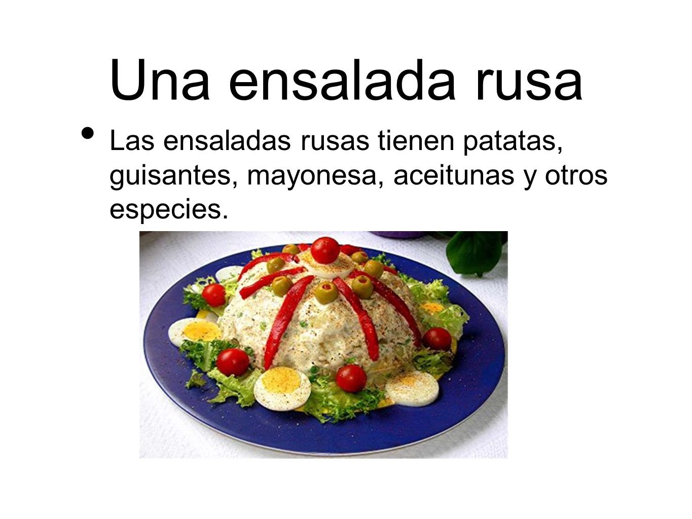 Una ensalada rusa Las ensaladas rusas tienen patatas, guisantes, mayonesa, aceitunas y otros especies.