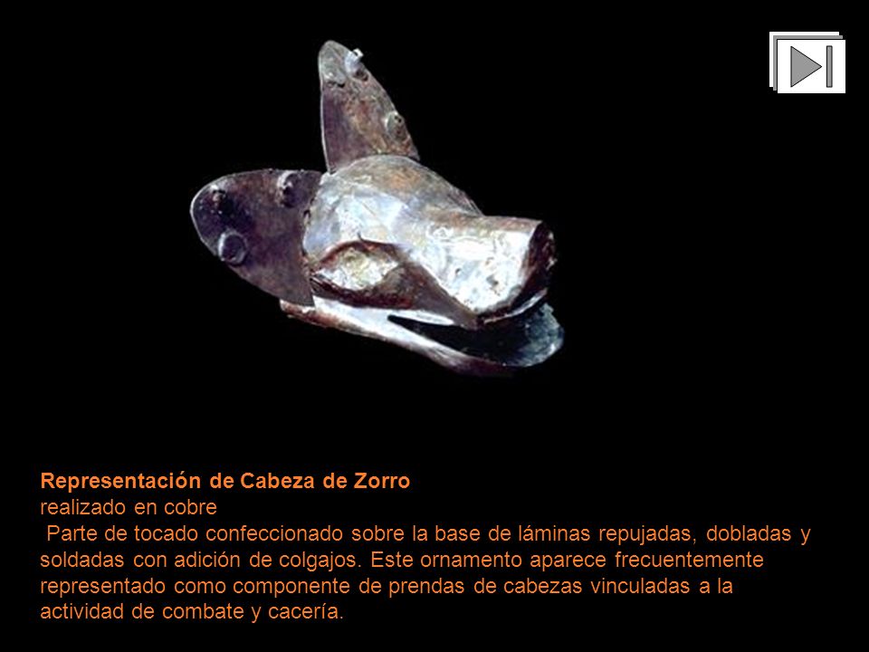 Representación de Cabeza de Zorro realizado en cobre Parte de tocado confeccionado sobre la base de láminas repujadas, dobladas y soldadas con adición de colgajos. Este ornamento aparece frecuentemente representado como componente de prendas de cabezas vinculadas a la actividad de combate y cacería.