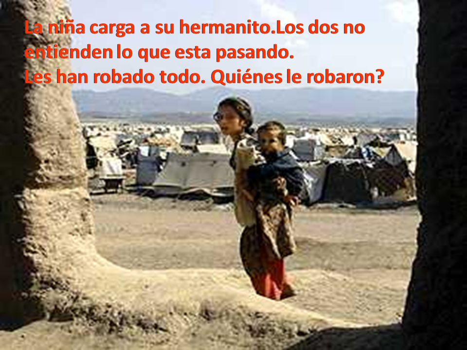 La niña carga a su hermanito.Los dos no entienden lo que esta pasando.