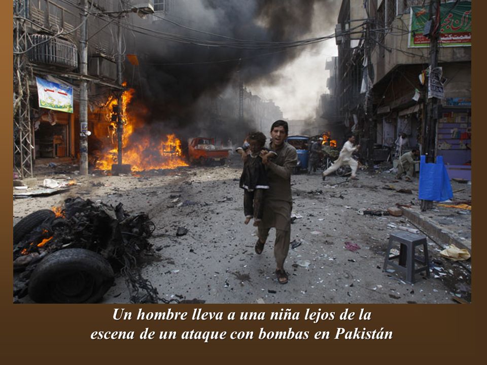 Un hombre lleva a una niña lejos de la escena de un ataque con bombas en Pakistán